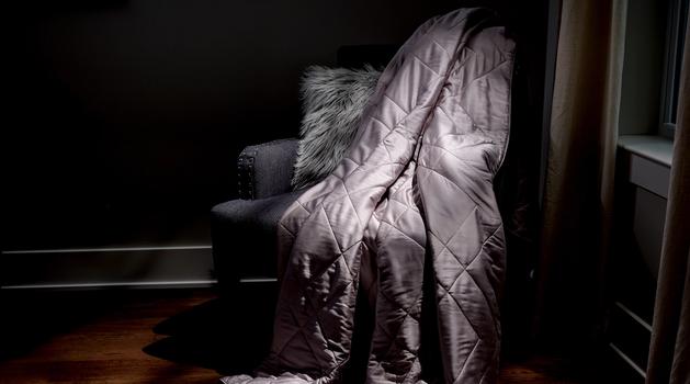 Dove Lightweight Blanket sitting on a chair as decor