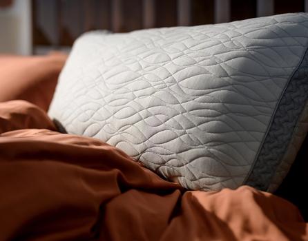 Dual Chamber Pillow resting on a bed with terracotta