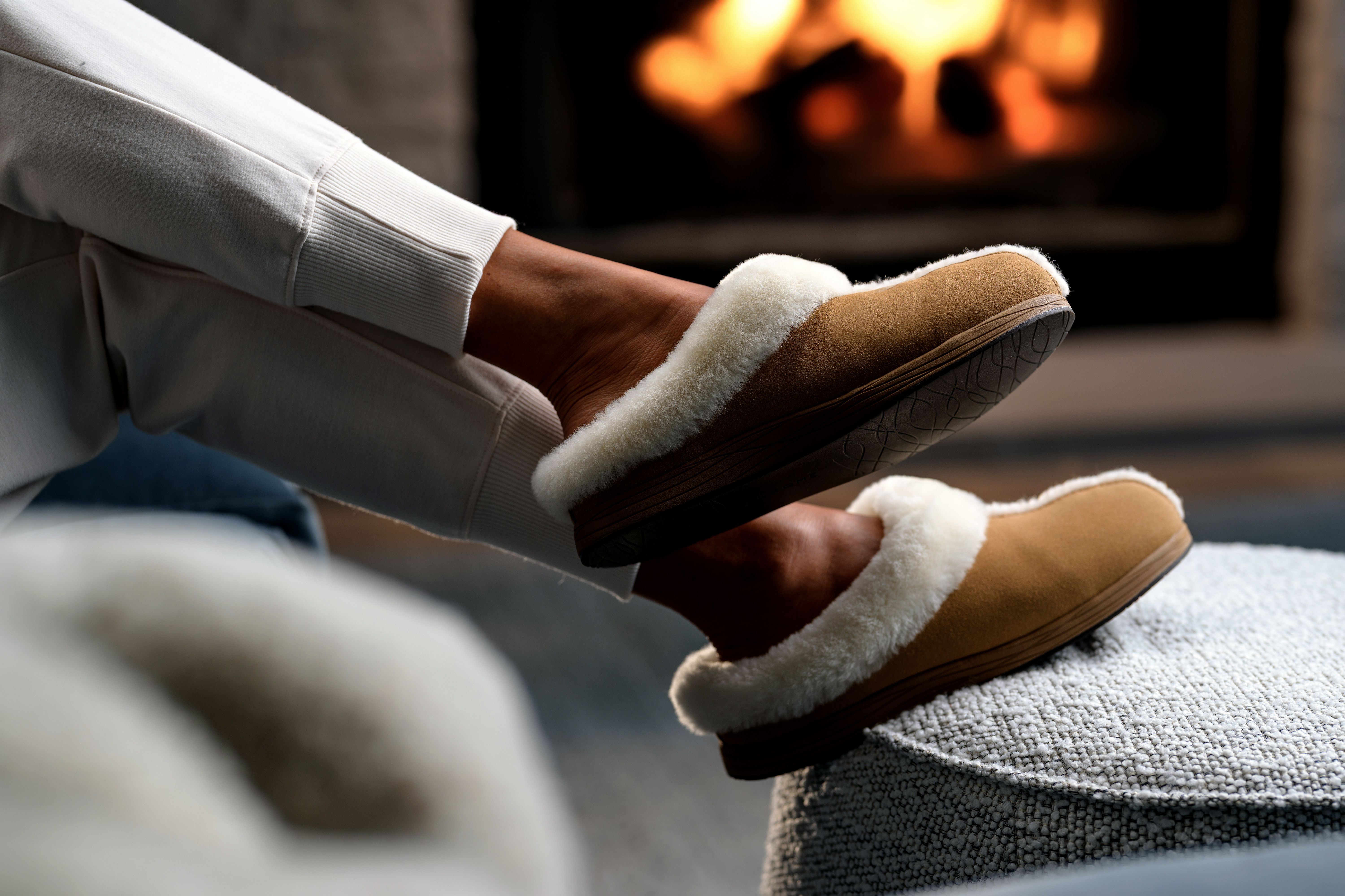Woman's feet propped up wearing Chestnut Signature Slipper and Almond jogger
