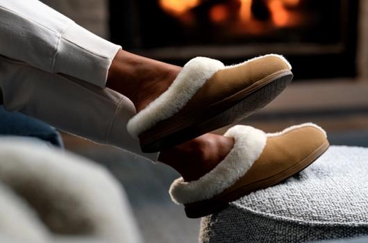 Woman's feet propped up wearing Chestnut Signature Slipper and Almond jogger