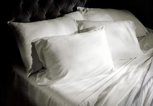 Luxury sheets in ivory on a bed