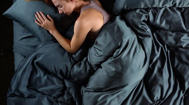 Women sleeping in cooling bamboo bedding in the color ocean