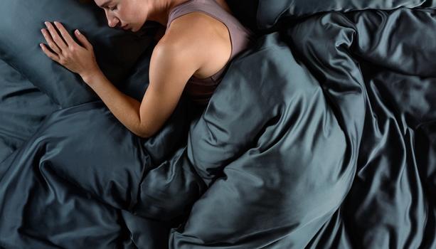 Women sleeping in cooling bamboo bedding in the color ocean