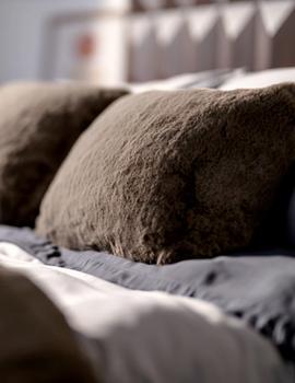 Truffle Faux fur Pillow sitting on bed