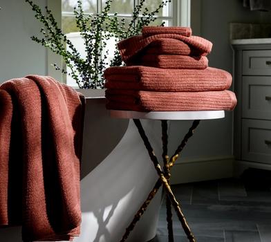 Clay Plush Performance Towels next to a bath tub