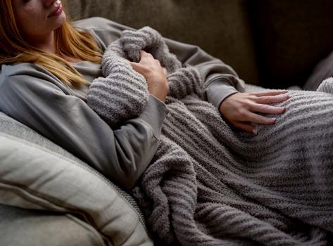 Cuddling under a cozy throw blanket in the color cloud