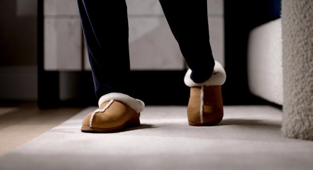 Man walking in bedroom with Chestnut Signature Slippers