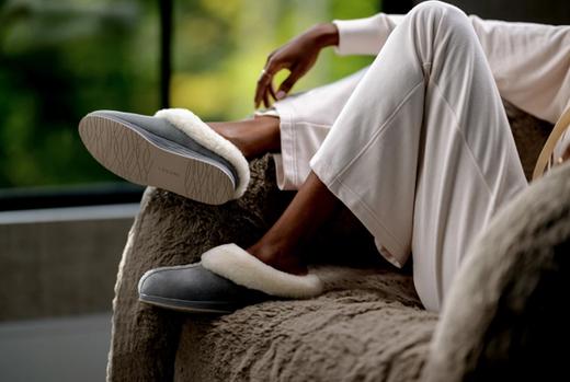 Woman lounging in chair wearing Ash Signature Slipper and Almond Loungewear