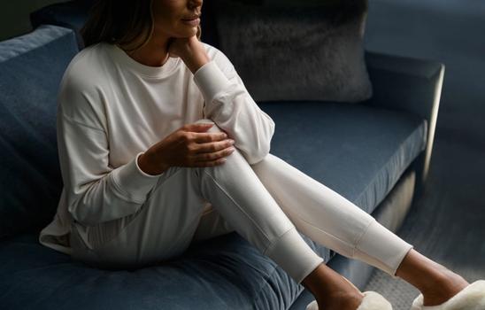 Woman wearing cozy loungewear in the color almond