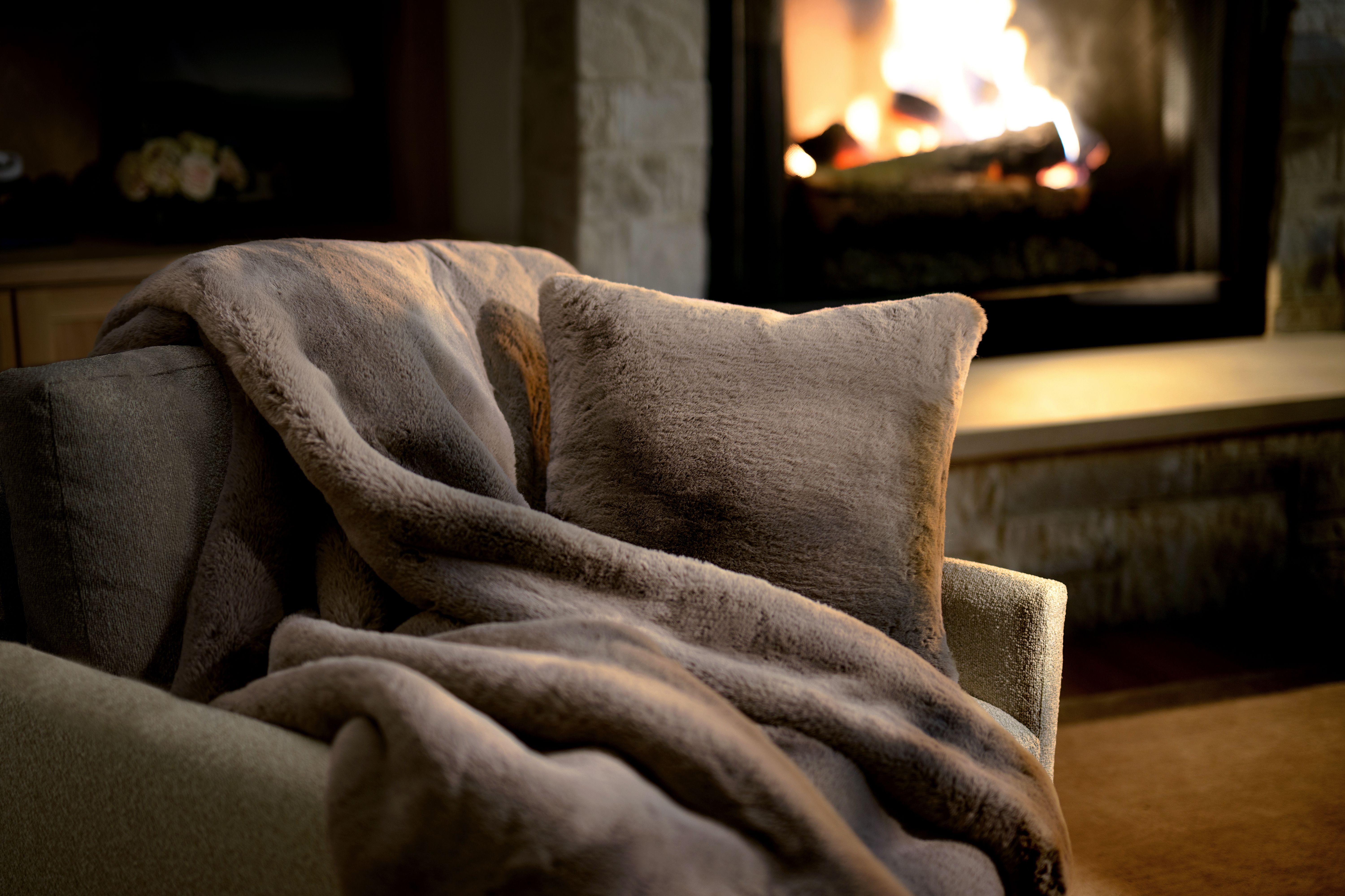 Truffle Faux Fur Pillow & Blanket by the fireplace