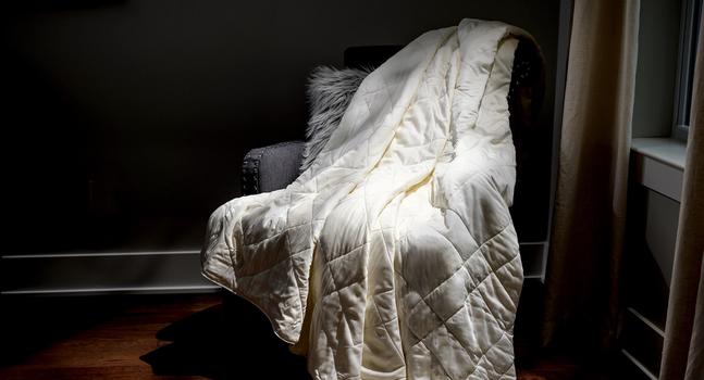Ivory Lightweight Blanket sitting on a chair as decor