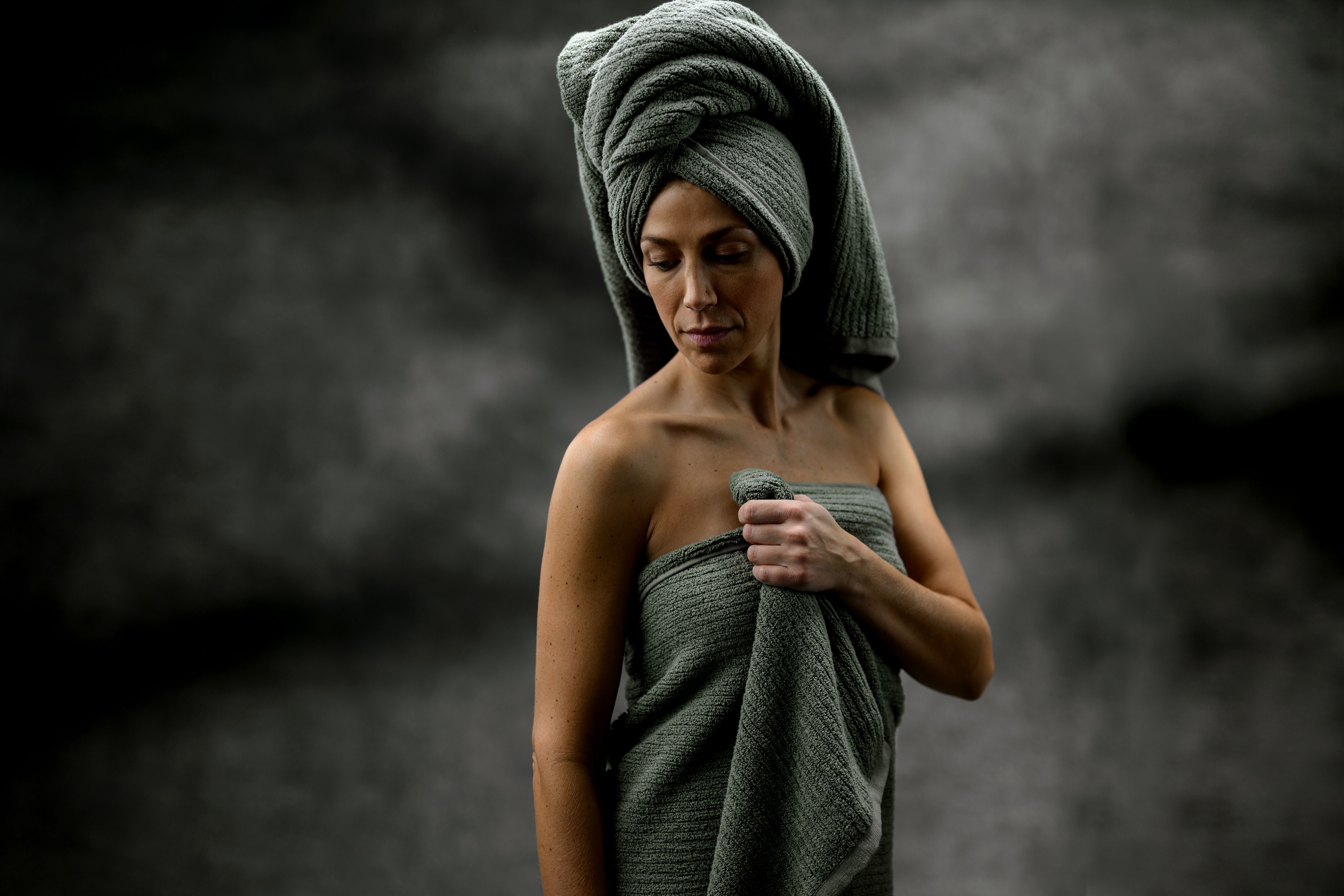 Woman wearing a luxurious bath sheet in the color moss
