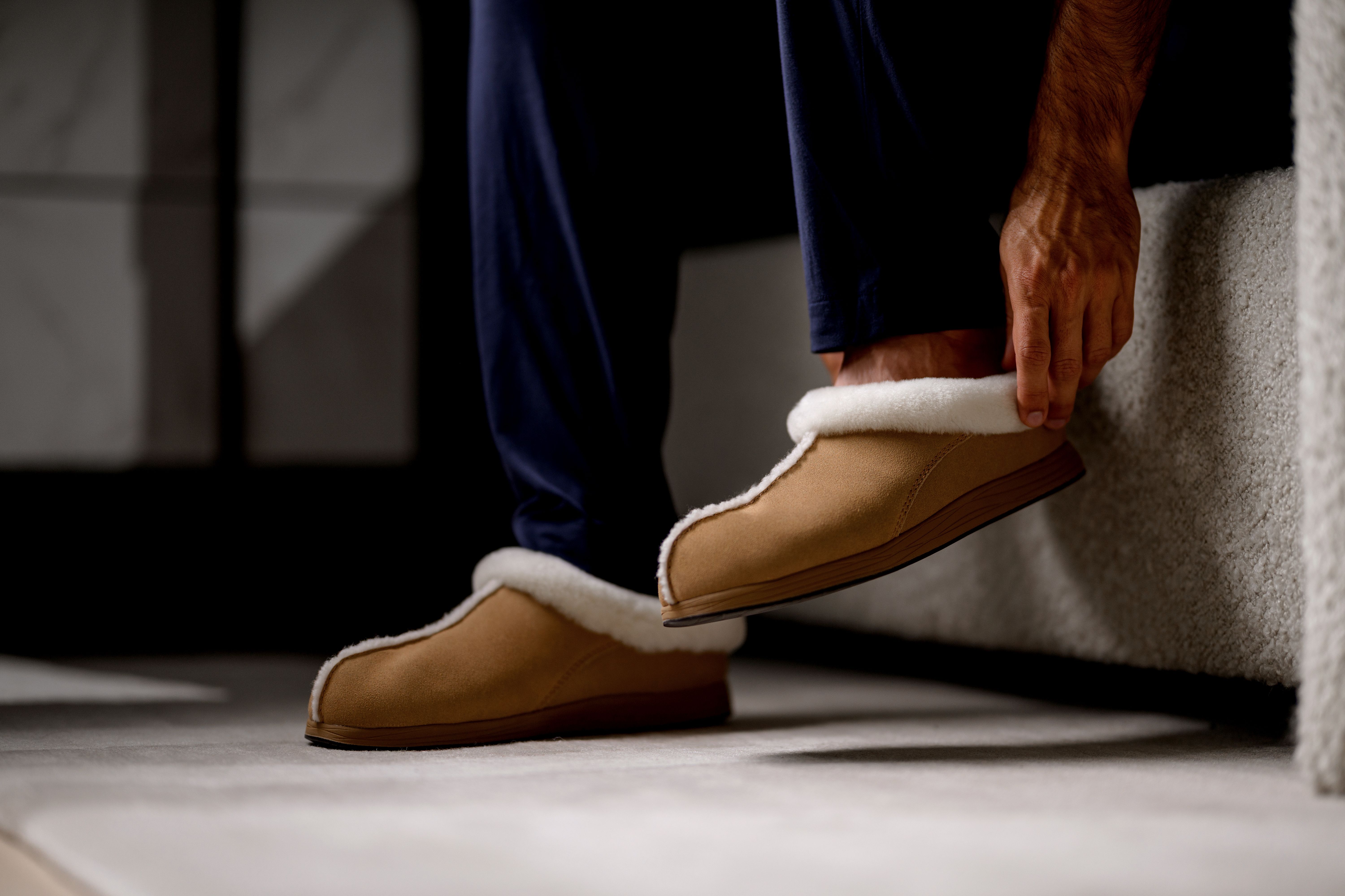 Man slipping on Chestnut Signature Slipper