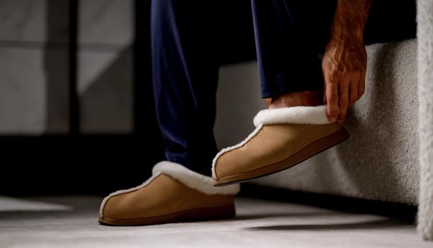 Man slipping on Chestnut Signature Slipper