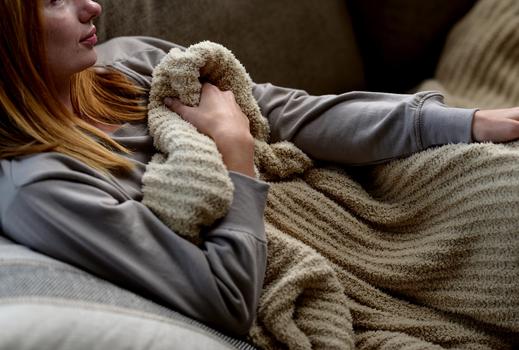 Cuddling under a cozy throw blanket in the color dune