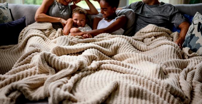 Generously sized blanket covering family comfortably
