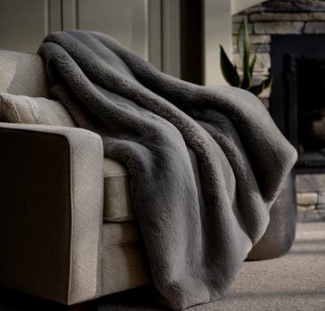 Faux Fur Blanket draped on chair in color Fog