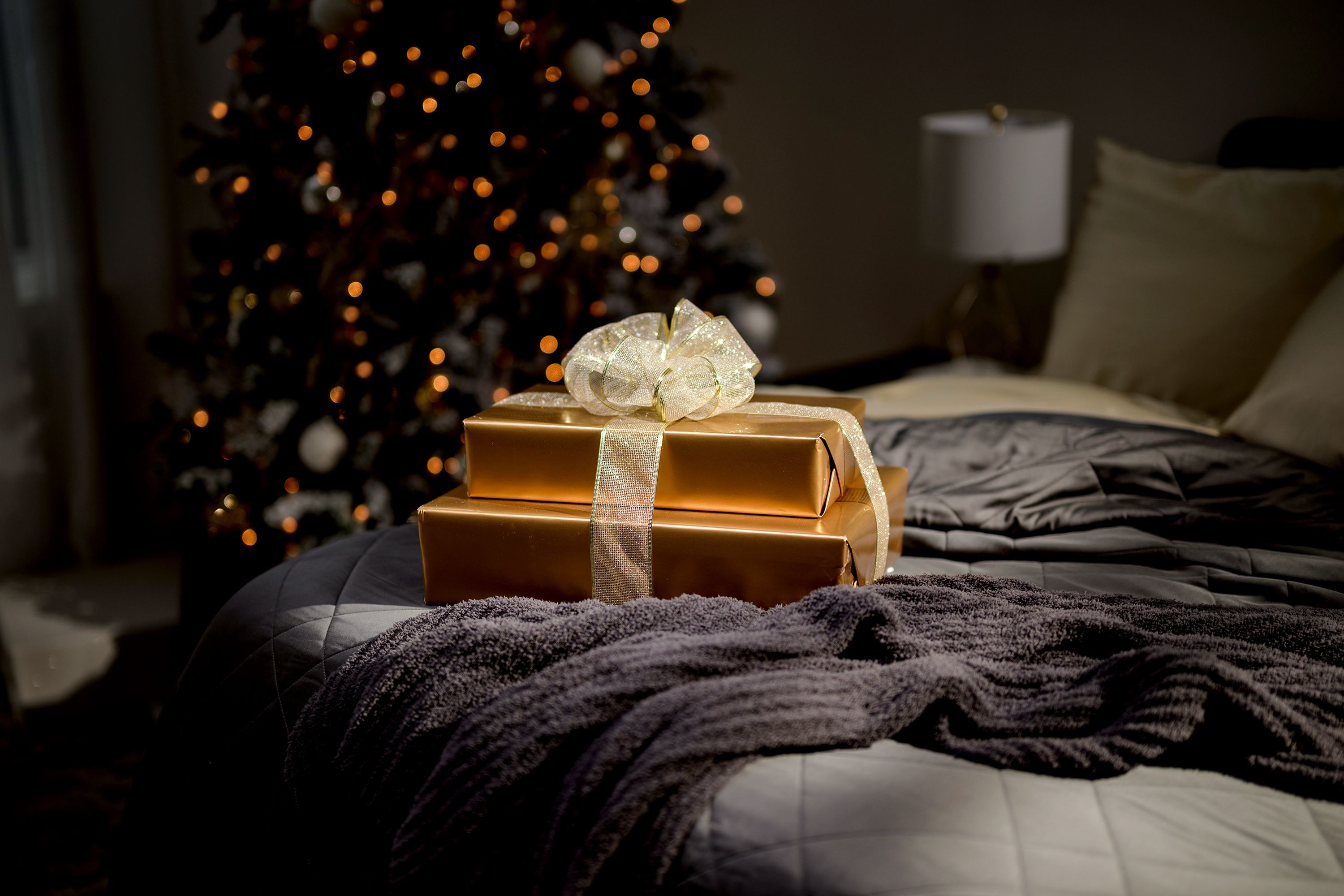 Presents sitting on a bed made of luxurious bedding