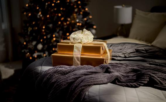 Presents sitting on a bed made of luxurious bedding