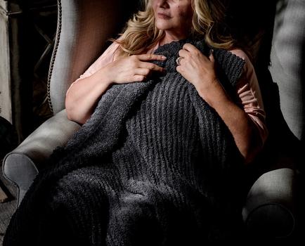Cuddling under a cozy throw blanket in the color charcoal