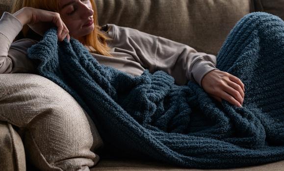 Cuddling under a cozy throw blanket in the color ocean