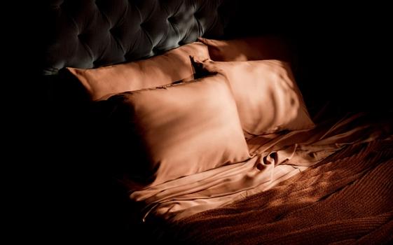 Luxury sheets in terracotta on a bed