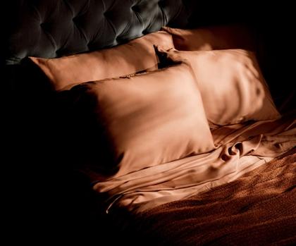Luxury sheets in terracotta on a bed