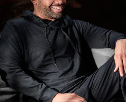 Man wearing the cozy Essential Hoodie in onyx