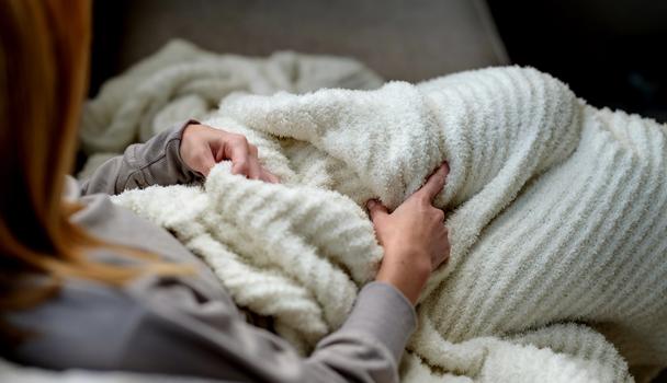 Cuddling under a cozy throw blanket in the color ivory
