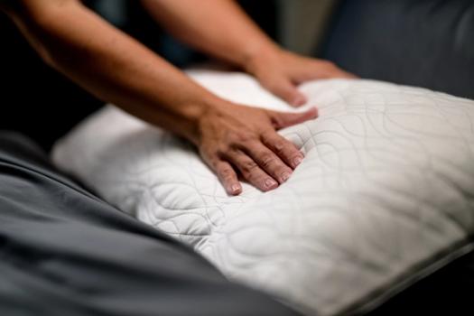 Pressing down on Dual Chamber Pillow to see its loft