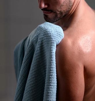Man drying off with quick drying towels in surf