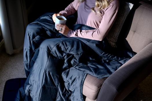 Woman cuddling under Navy integrated One-Piece Weighted Blanket