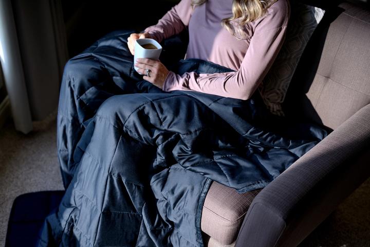 Woman cuddling under Navy integrated One-Piece Weighted Blanket