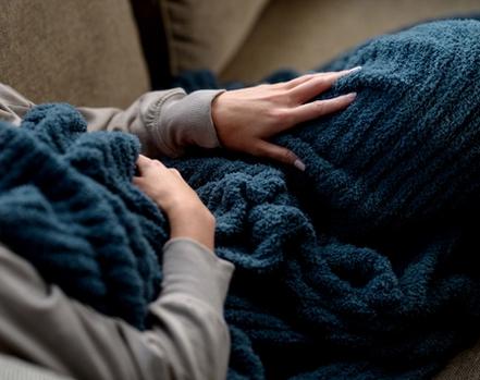 Cuddling under a cozy throw blanket in the color ocean