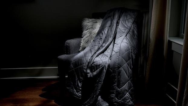 Charcoal Lightweight Blanket sitting on a chair as decor