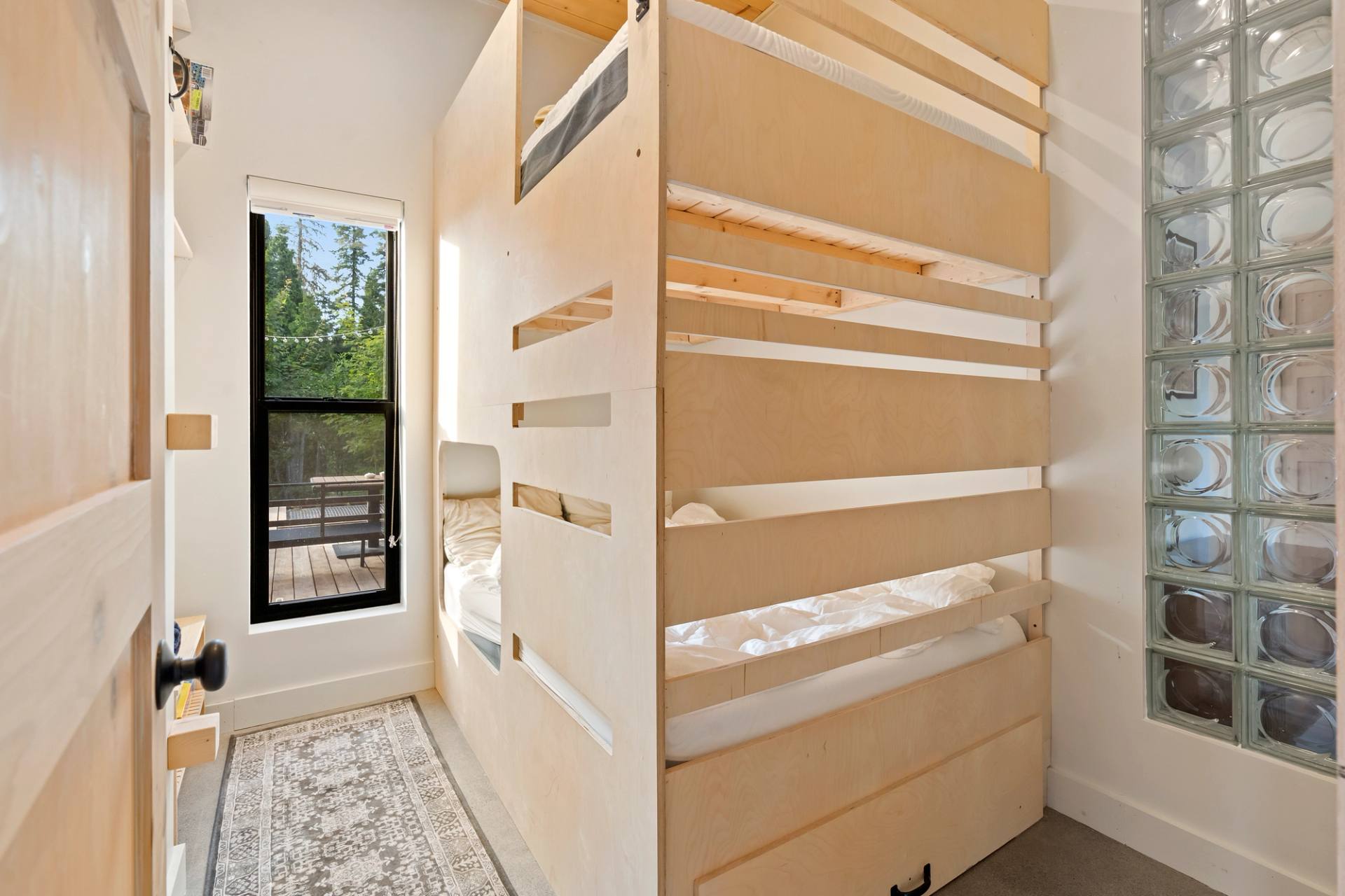 Entree du chalet avec banc et escalier, murs en bois clair