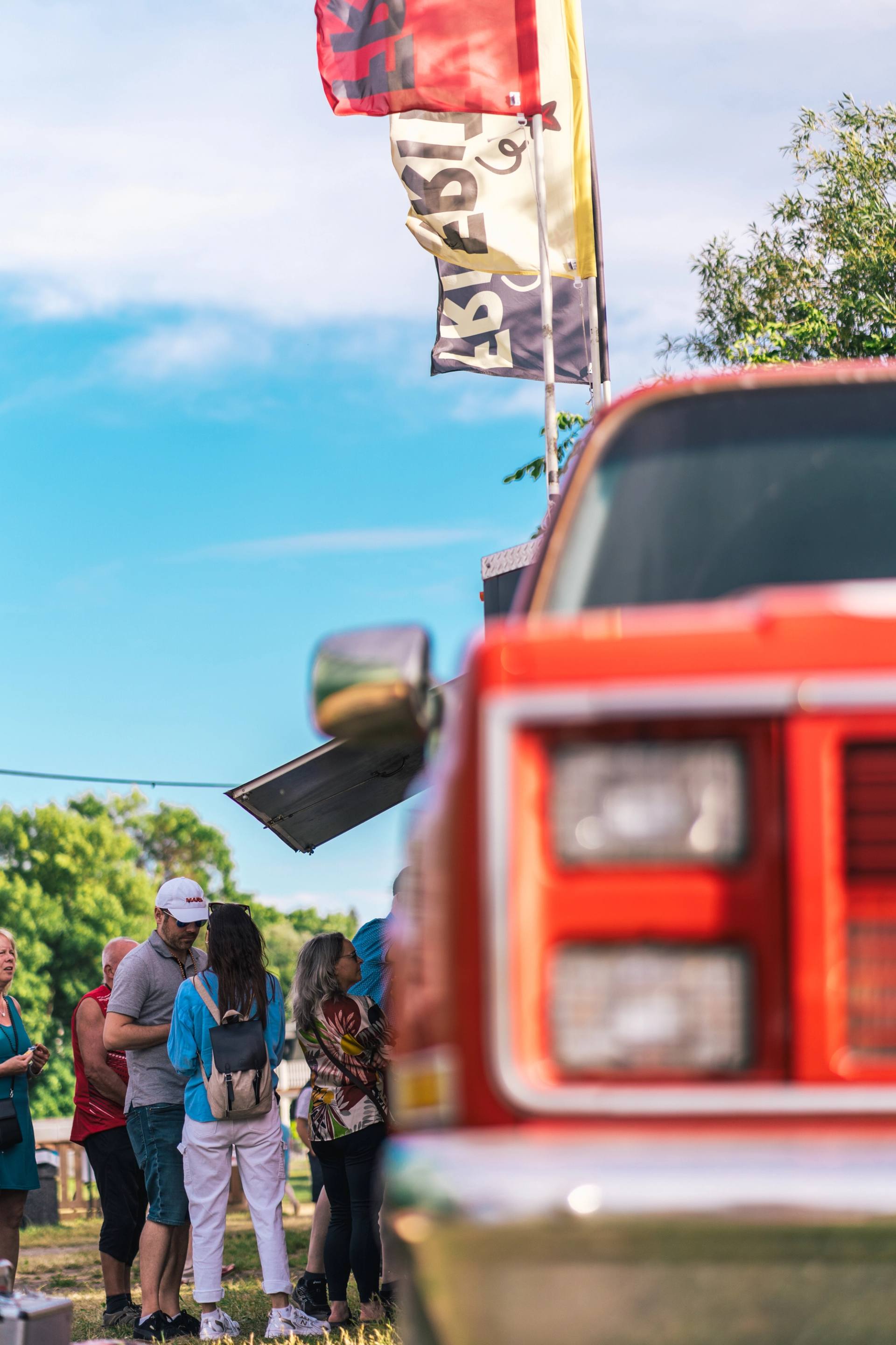 Camion rouge en arriere-plan d'une scene de fete exterieure