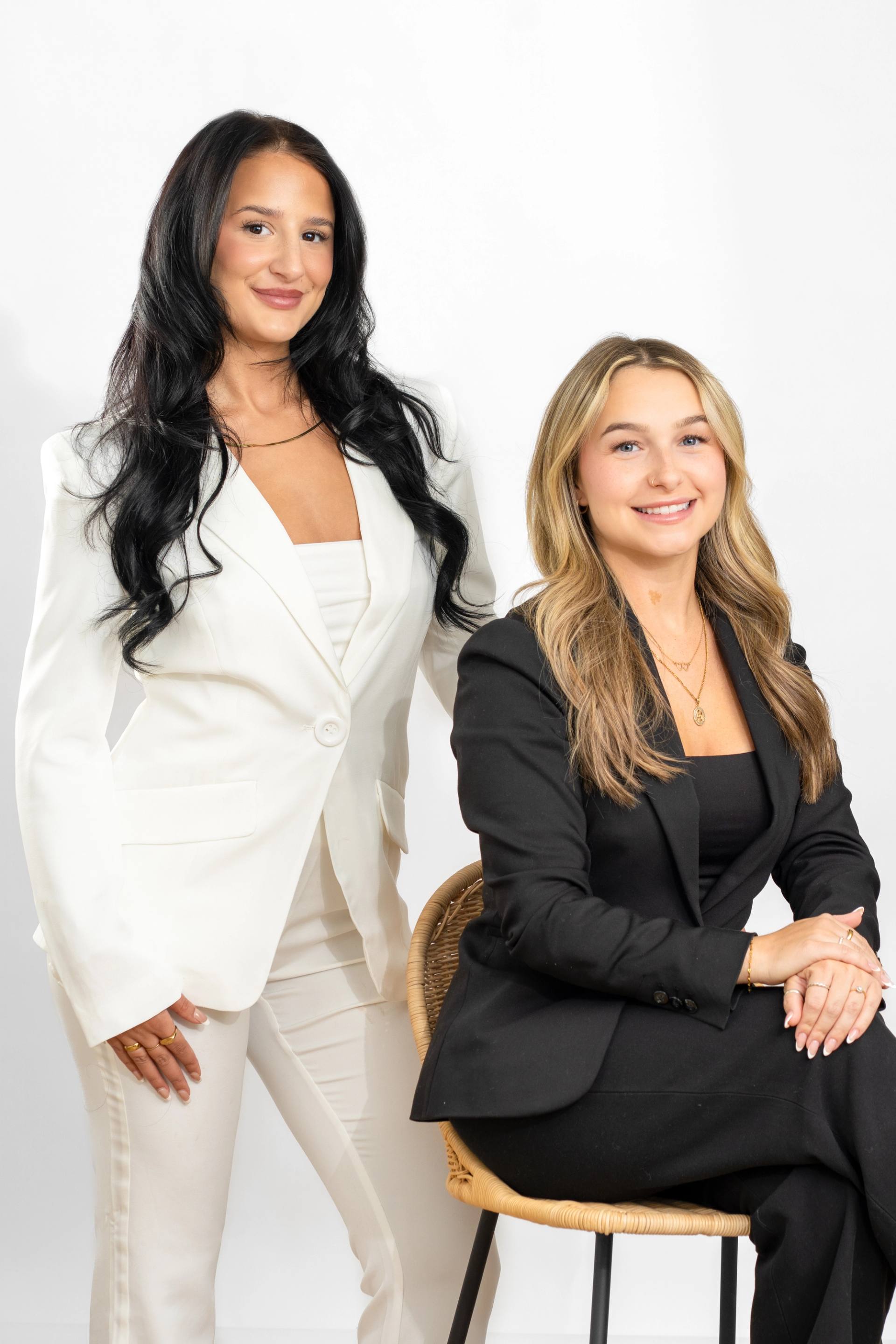 Portrait de deux collegues debout cote a cote, sur fond blanc de studio