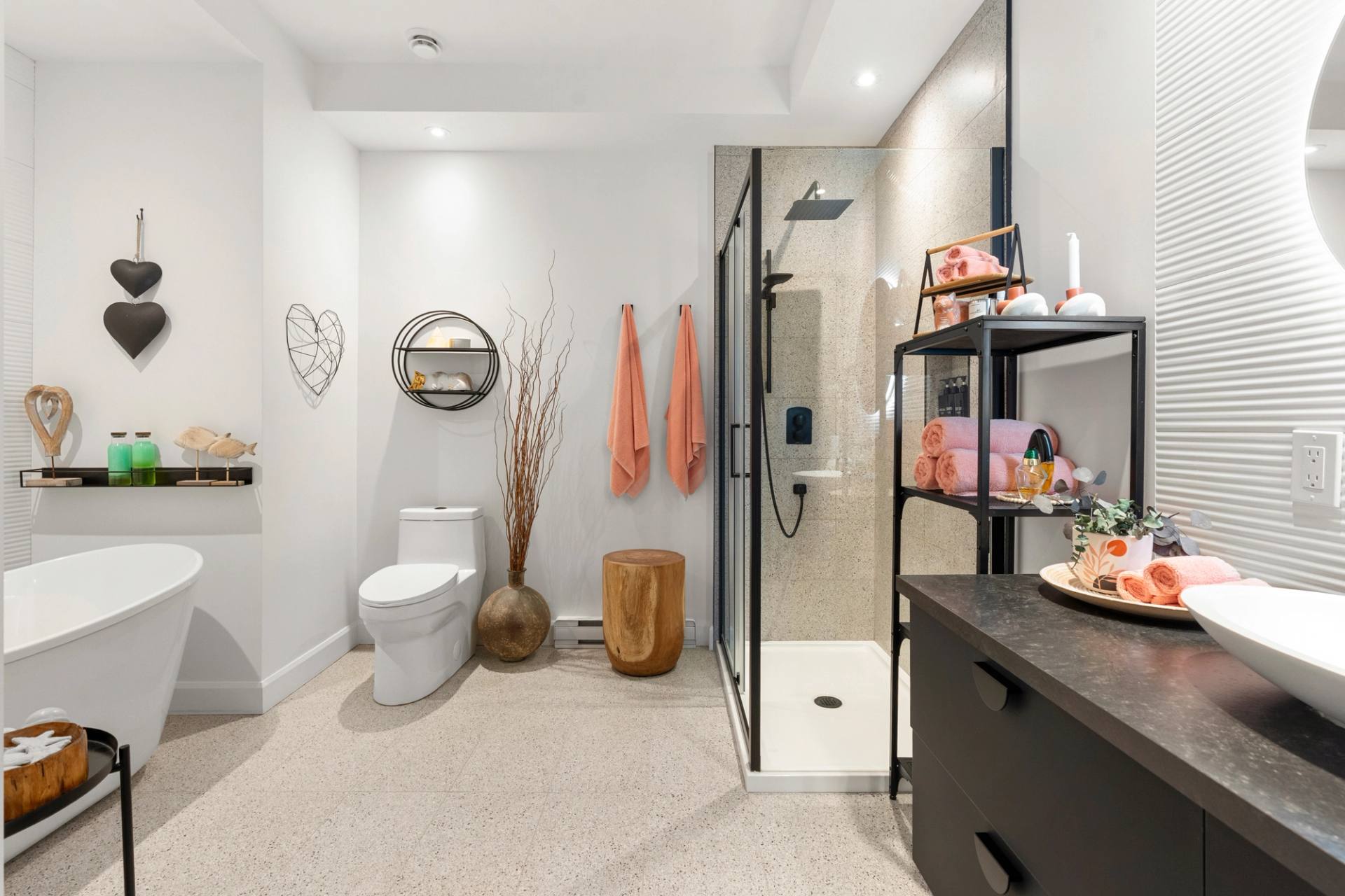 Salle de bain avec baignoire autoportante, douche vitrée et vanité noire
