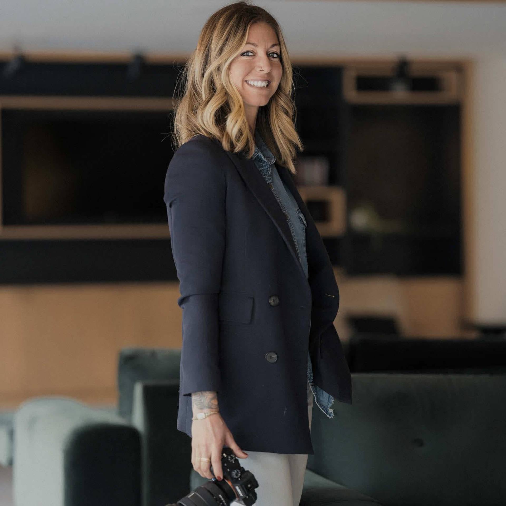 Nelly Dufour, appareil photo à la main, dans un intérieur lumineux