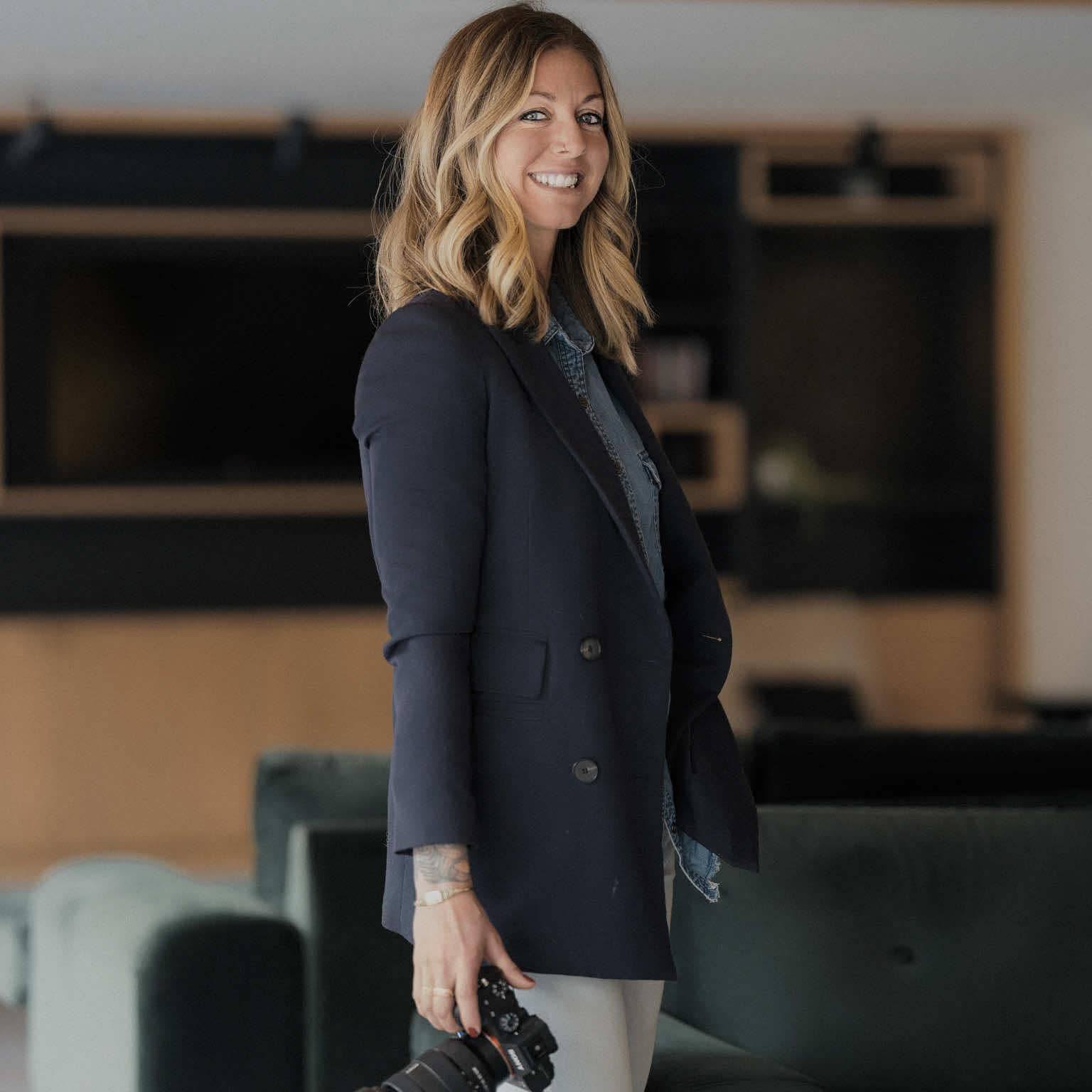 Nelly Dufour, appareil photo à la main, dans un intérieur lumineux