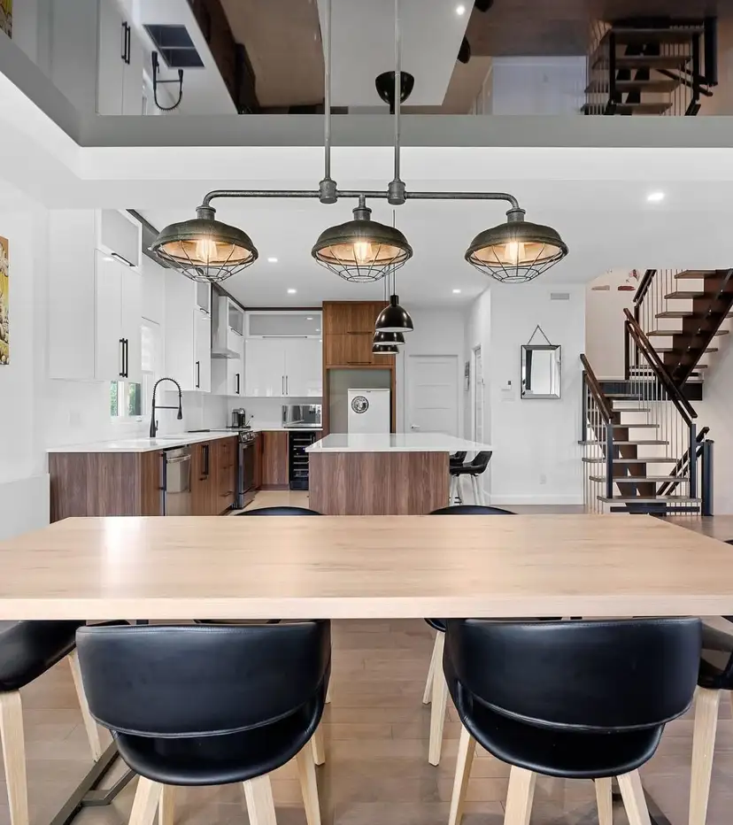 Aire ouverte avec cuisine, salle à manger et mezzanine sous un plafond cathédrale