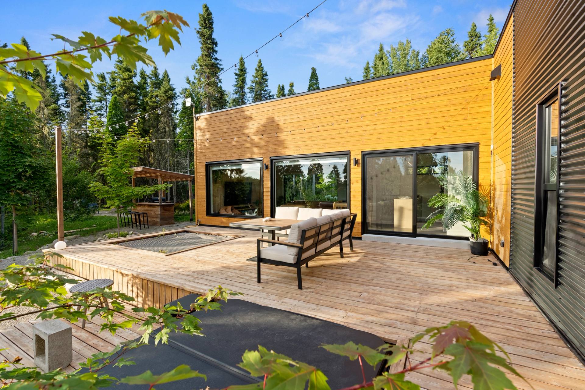 Grande terrasse en bois meublee pour recevoir, en bordure de foret