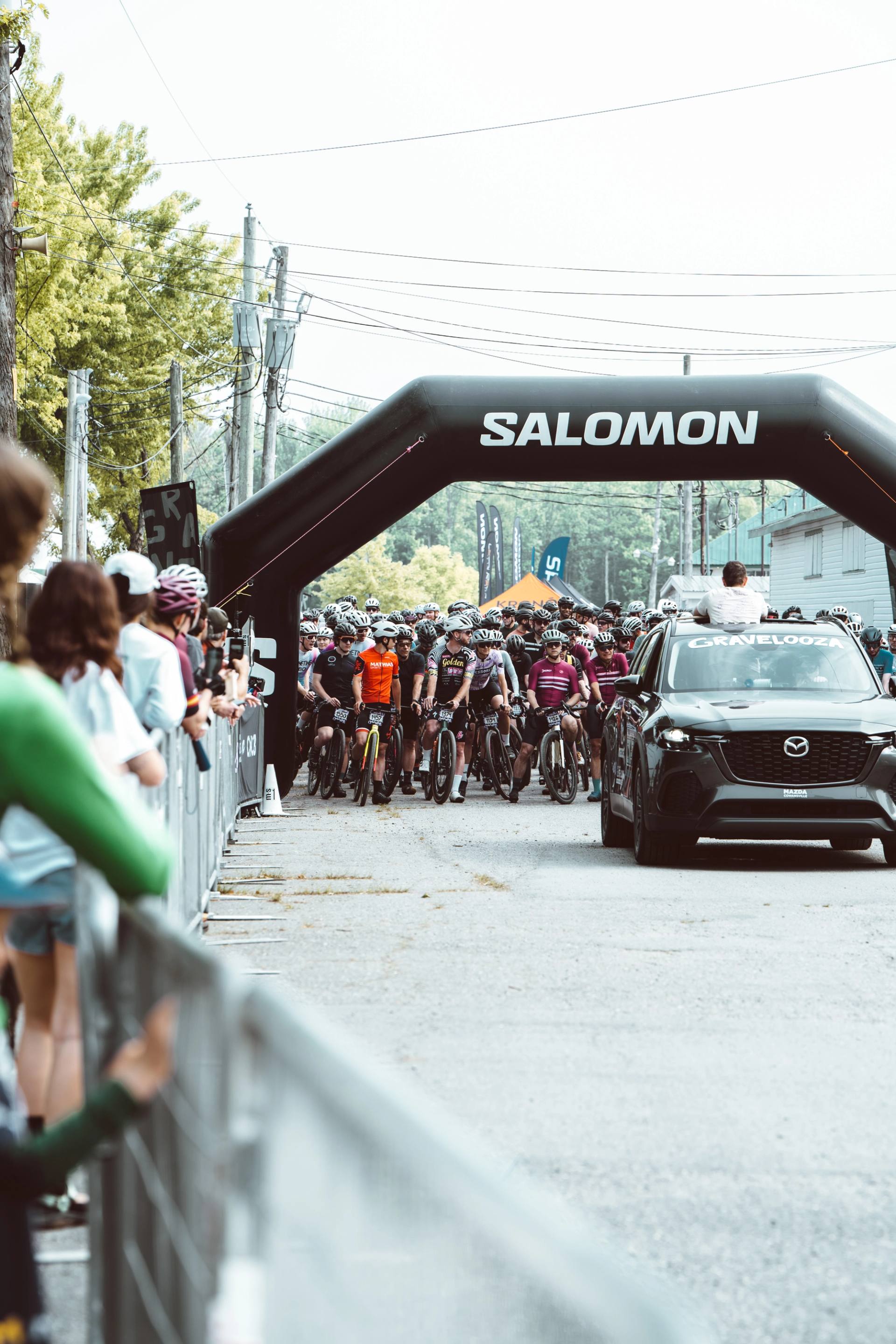 Depart de la course cycliste Gravelooza sous l'arche gonflable des partenaires