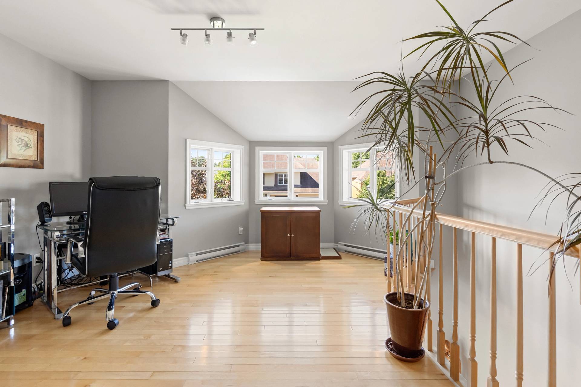 Mezzanine amenagée en bureau, chaise de travail noire et classeur de bois
