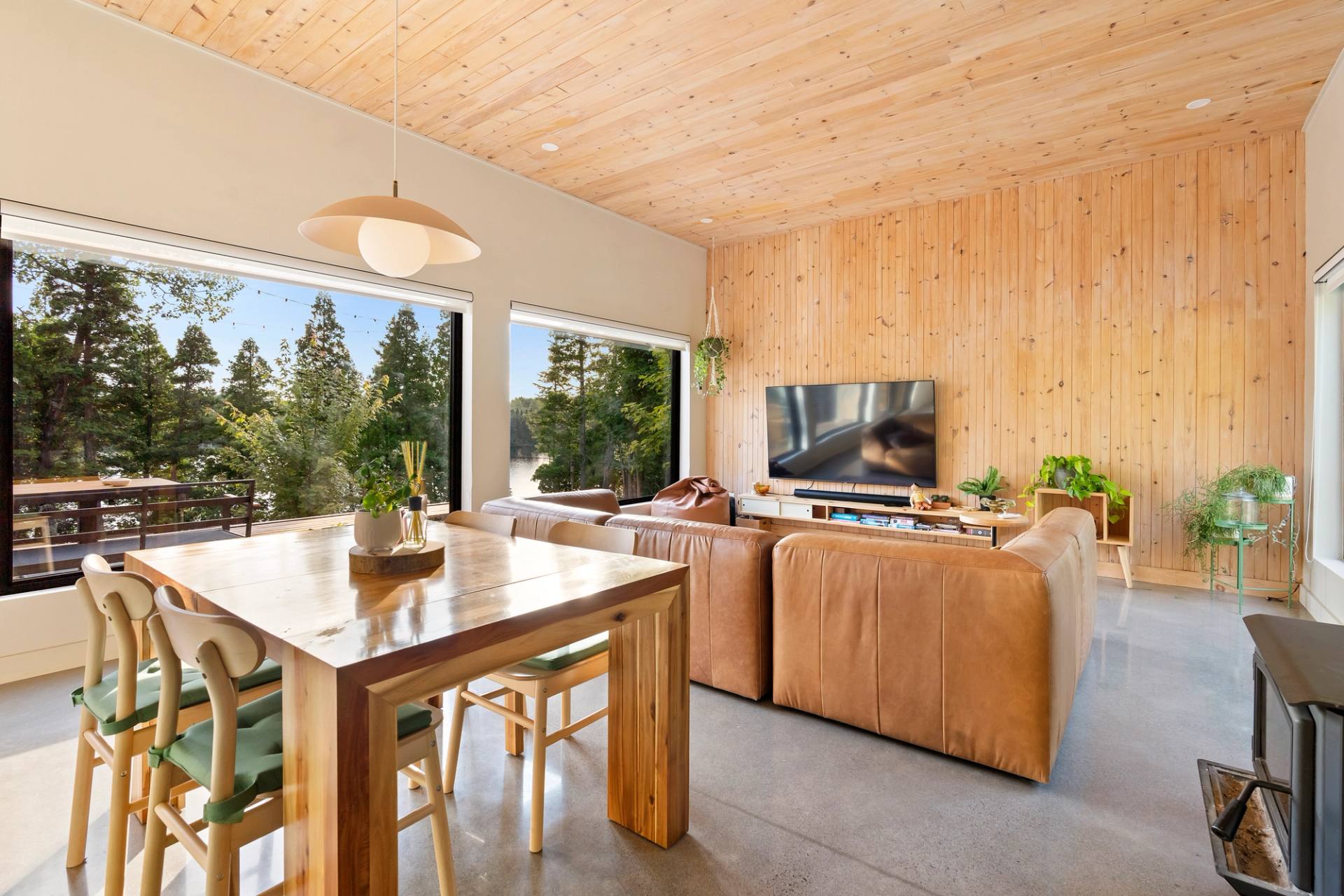 Cuisine et salle a manger du chalet en bois clair, vue directe sur le lac