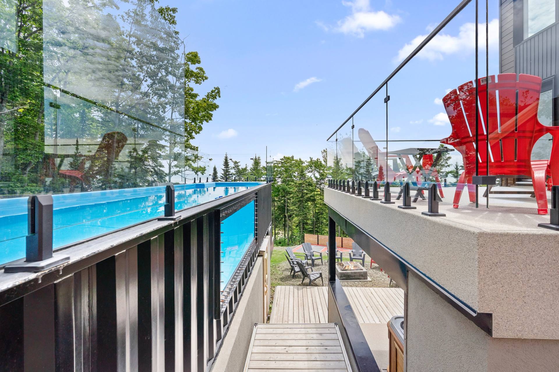 Terrasse avec piscine creusee et garde-corps de verre, vue degagee