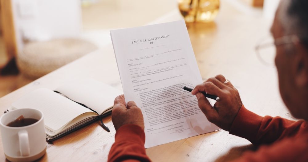 Person reviewing and signing a last will and testament at a table, representing undue influence concerns in Pennsylvania probate disputes.