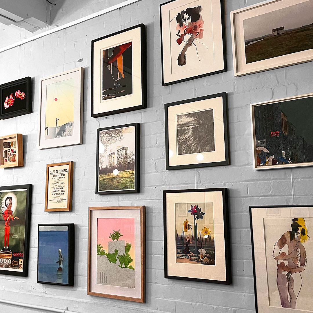 salon hang of artwork on brick wall