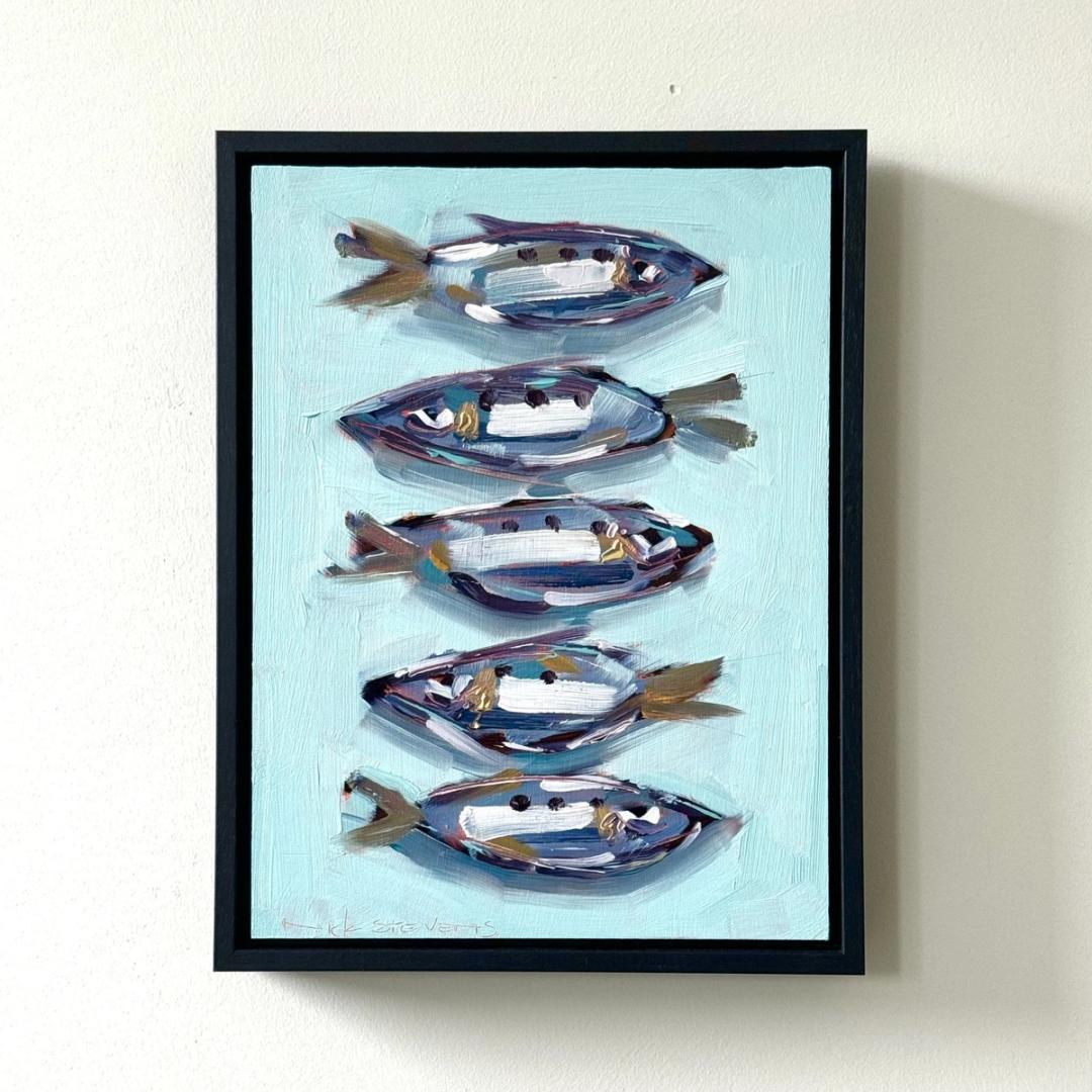 This image is a photograph of a framed painting titled "Five Sardines on Faded Teal" by Nick Stevens. The artwork features five sardines painted in a bold, expressive style. The fish are arranged in a vertical line, one above the other, against a textured background of faded teal. Each sardine is depicted with broad, visible brushstrokes in a mix of silver, blue, purple, and hints of gold, with distinctive dark spots along their bodies. The tailfins are rendered in shades of bronze and brown. The overall effect is vibrant and dynamic, with a sense of movement and a slightly abstracted realism. The painting is displayed in a simple black frame and hangs on a plain white wall.